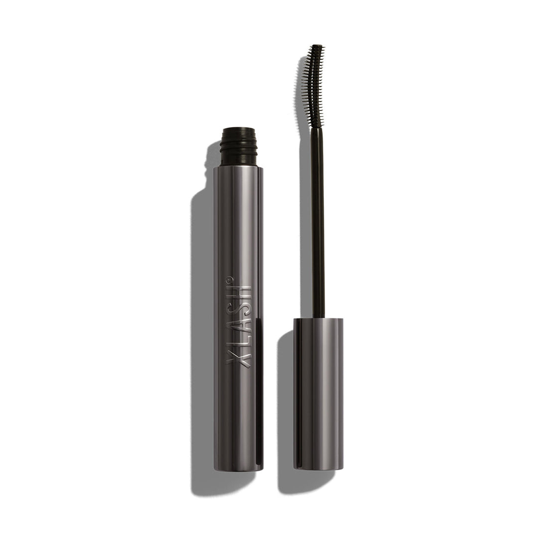 Xlash Drama Tinted Primer -ripsivärinpohjustaja tyylikkäässä tumman hopeassa hylsyssä ja siro silikoniharja.